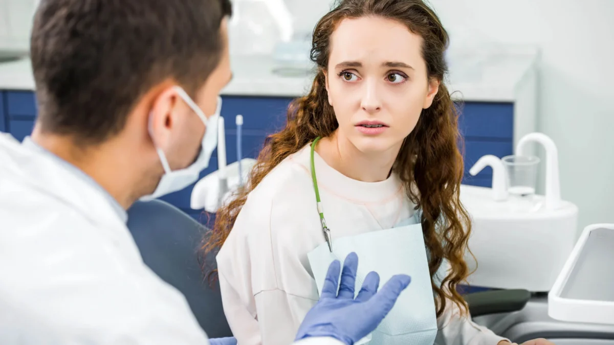 A worried-looking patient is looking at an emergency dentist in Matthews, NC