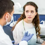 A worried-looking patient is looking at an emergency dentist in Matthews, NC
