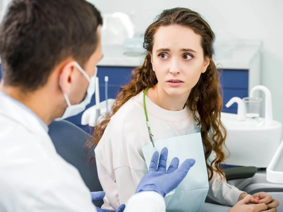 A worried-looking patient is looking at an emergency dentist in Matthews, NC