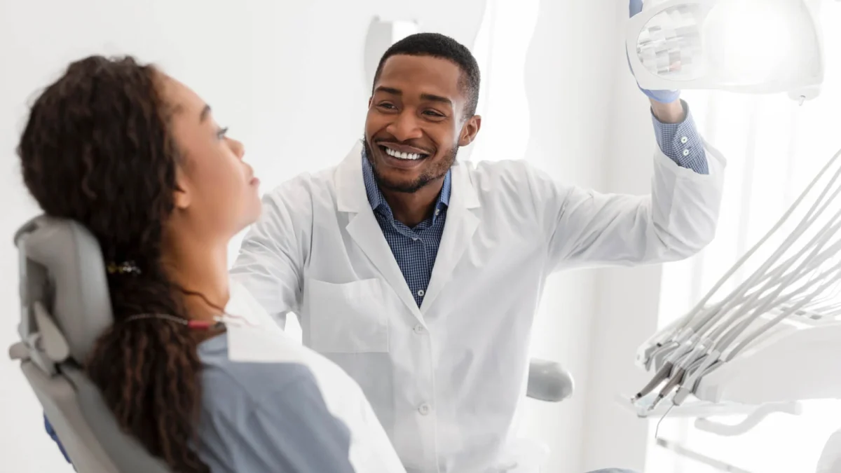 One of the best dentist in Matthews, NC, turning on equipment before check-up and greeting patient