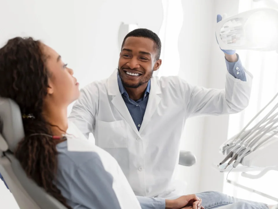One of the best dentist in Matthews, NC, turning on equipment before check-up and greeting patient