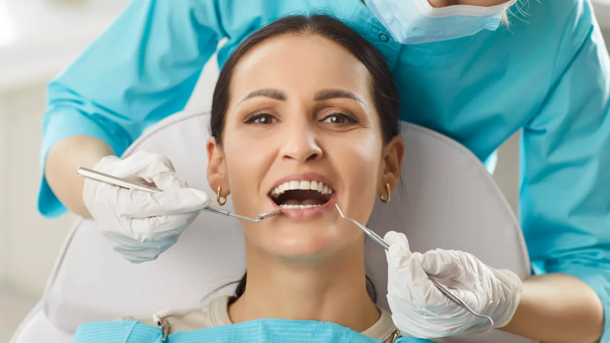 A dentist in Indian Trail, NC, examines a woman patient's oral care during a clinic visit.