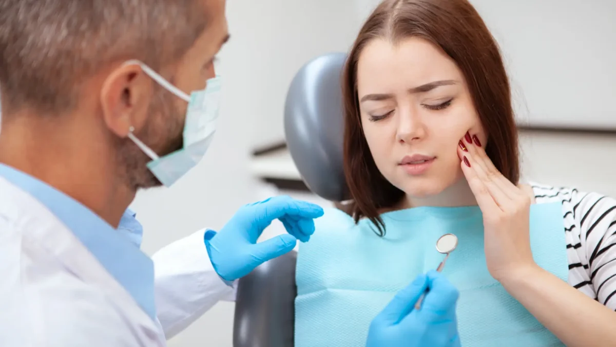Young woman with toothache visiting emergency dentist Matthews NC
