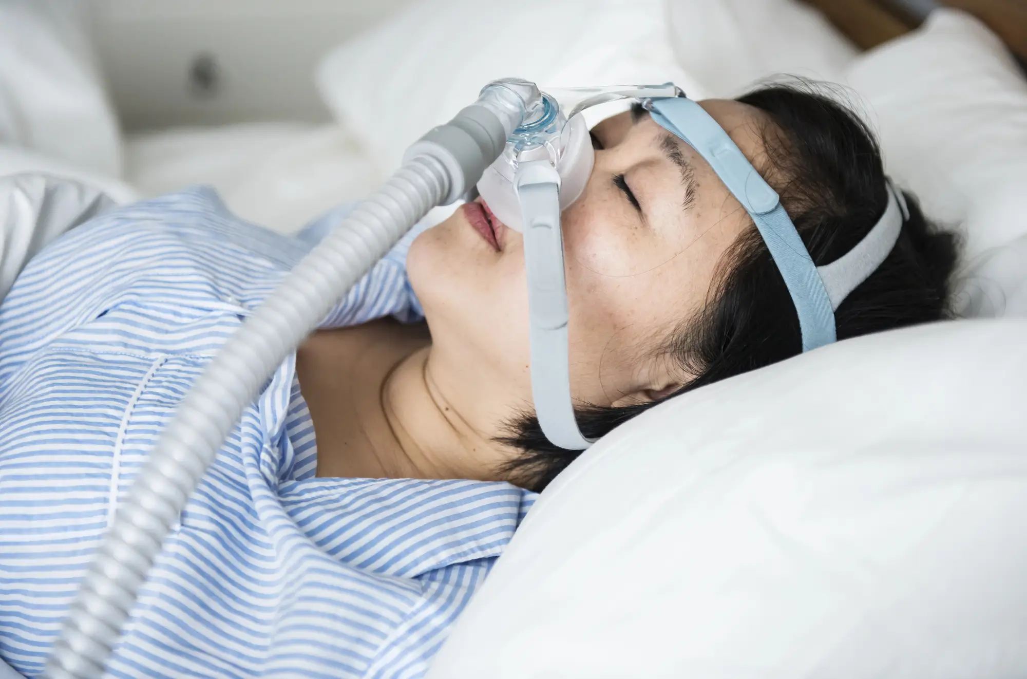 Woman using a chin strap for sleep apnea in Matthews, NC